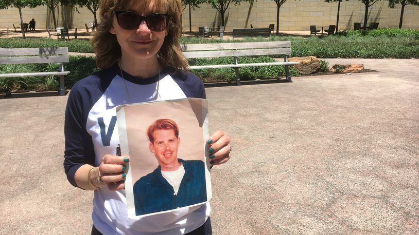 Kim Russell with a photo of her friend Philip Rau, who was shot to death in Inman Park in 1999, at a Dallas rally protesting the NRA's political clout. Photo: Jennifer Brett, jbrett@ajc.com