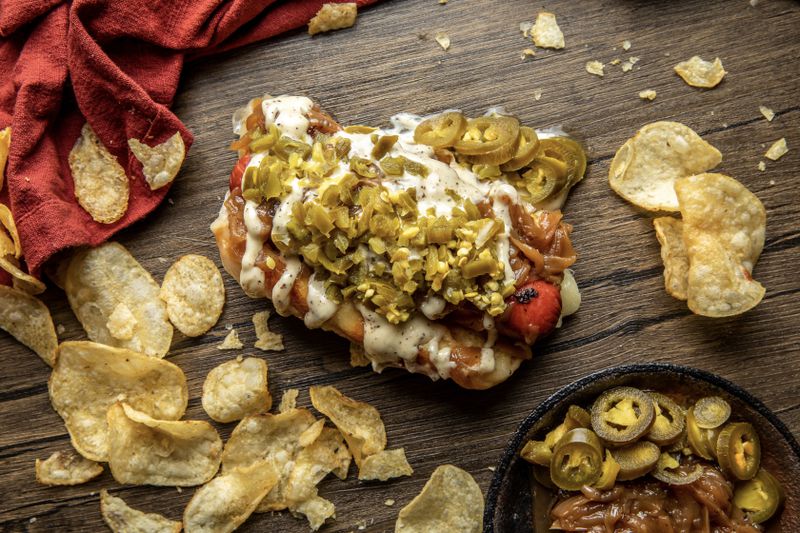The Damn Dog from Pepper's Hot Dogs includes  caramelized onions, jalapeno and truffle aioli. / Courtesy of @bitesandbevsmedia