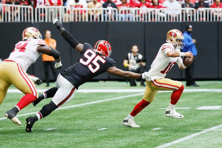 Falcons defensive tackle Ta'Quon Graham tries to stop  49ers quarterback Jimmy Garoppolo during the third quarter Sunday at Mercedes-Benz Stadium. (Miguel Martinez / miguel.martinezjimenez@ajc.com)
