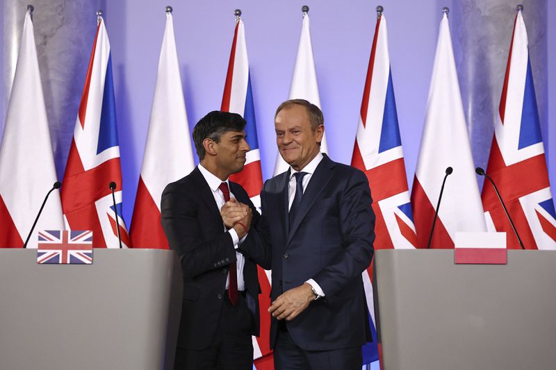 Prime Minister Rishi Sunak, left, and Polish Prime Minister Donald Tusk shake hands after addressing a press conference following bilateral talks at the Prime Minister's office in Warsaw, Poland, on Tuesday April 23, 2024. (Henry Nicholls, Pool Photo via AP)