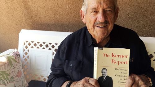 In this Aug. 31, 2017, photo, former U.S. Sen. Fred Harris of Oklahoma holds a copy of “The Kerner Report” at his home in Corrales, N.M., as he discusses the 50th anniversary of the Kerner Commission, a panel appointed by President Lyndon Johnson in 1967 to examine the causes of the 1960s riots. Harris is the last surviving member of the Kerner Commission, and he says he remains haunted that its recommendations on U.S. race relations and poverty were never adopted. AP PHOTO / RUSSELL CONTRERAS