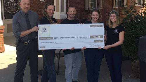 Farmhouse Coffee & Crepes presents a check made out to the Johns Creek Public Safety Foundation for $800.