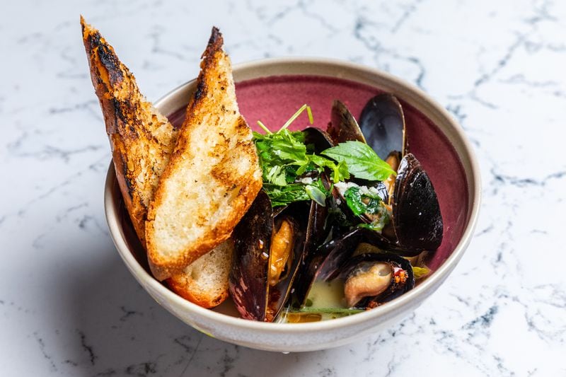 Juniper Cafe's mussels are served in a rich lemongrass and coconut broth, with thin strips of starfruit.  Courtesy of Eric Sun