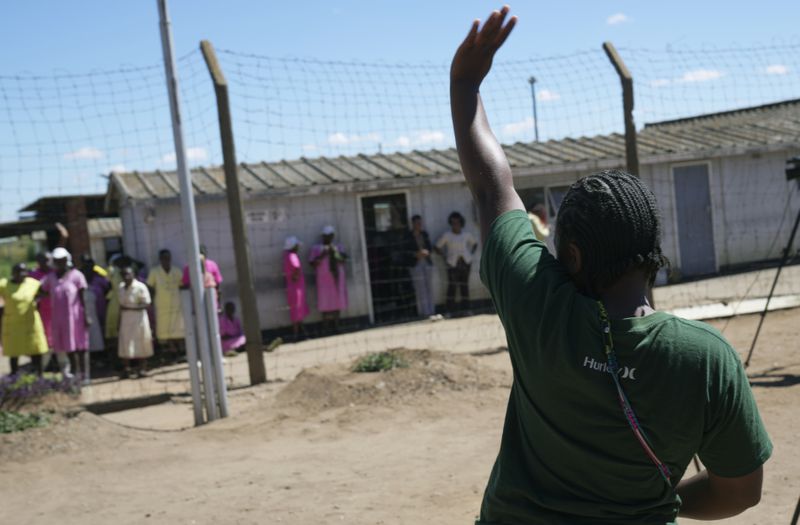 A female prisoner waves to her former inmates after being released from Chikurubi female prison on the outskirts of the capital Harare, Thursday, April 18, 2024. Zimbabwe President Emmerson Mnangagwa has granted amnesty to more than 4,000 prisoners in an independence day amnesty. The amnesty coincided with the country's 44th anniversary of independence from white minority rule on Thursday and included some prisoners who were on death row. (AP Photo/Tsvangirayi Mukwazhi)