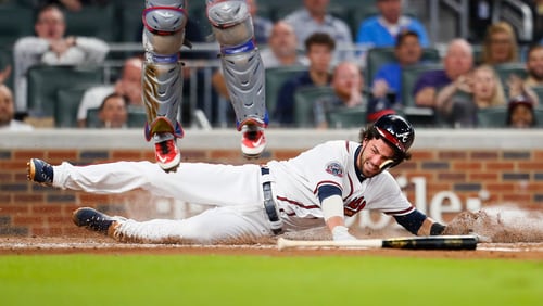 Atlanta Braves Dansby Swanson slides in to score a run in the second inning of the second game of a baseball doubleheader against the Texas Rangers, Wednesday, Sept. 6, 2017, in Atlanta. (AP Photo/Todd Kirkland)