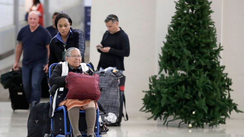 An employee pushes a woman on a wheelchair out of the international arrivals area on Terminal B at Newark Liberty International Airport on Nov. 21, 2017, in Newark, N.J.