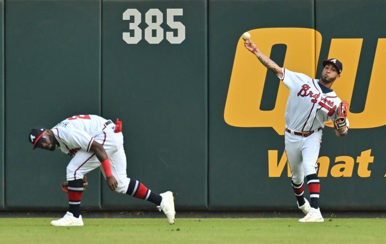 Atlanta Braves' Eddie Rosario, backed up by Michael Harris, fields a double by Phillies' Bryce Harper during the sixth inning of game one of the baseball playoff series between the Braves and the Phillies at Truist Park in Atlanta on Tuesday, October 11, 2022. (Hyosub Shin / Hyosub.Shin@ajc.com)
