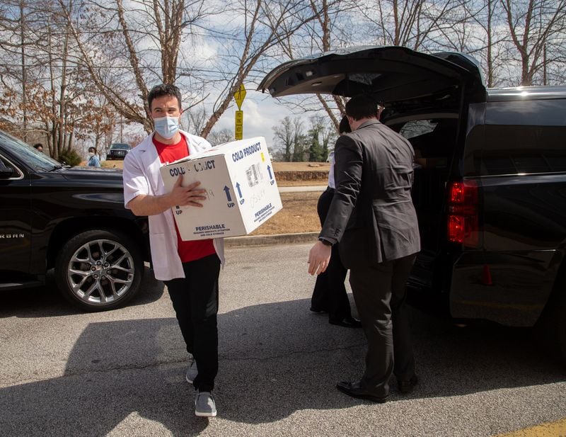 Walgreens employee Taylor Truelove rushes a new supply of the Pfizer vaccine into St. Philip AME Church during a vaccination event earlier this month. (STEVE SCHAEFER FOR THE ATLANTA JOURNAL-CONSTITUTION)