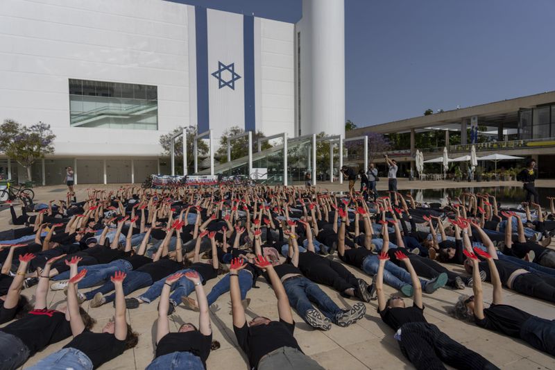Family and supporters of hostages held in the Gaza Strip hold up their hands, painted red to symbolize blood, to call for the captives' release and to mark 200 days since the Hamas-led Oct. 7 cross-border attack, in Tel Aviv, Israel, Tuesday, April 23, 2024. (AP Photo/Ohad Zwigenberg)