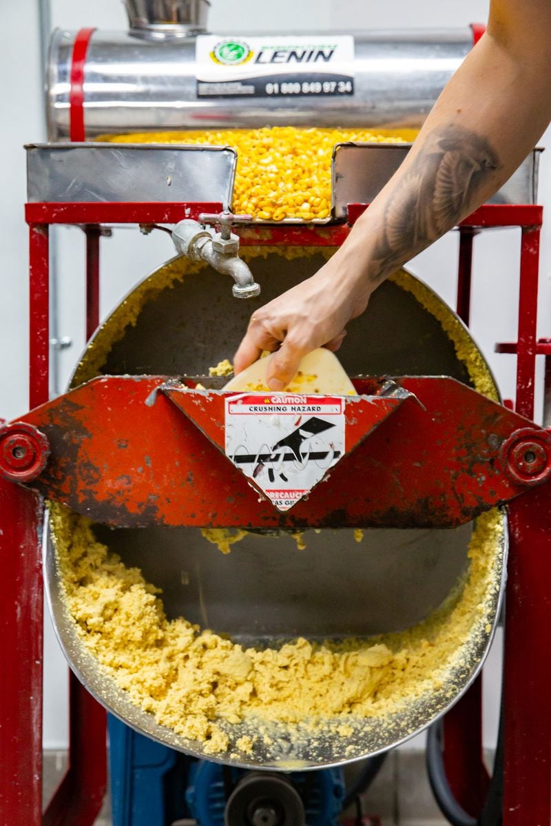 As part of the tortilla-making process, Aaron Harris uses a molino to grind yellow corn kernels that have been cooked and soaked in limewater into masa. Ryan Fleisher for The Atlanta Journal-Constitution 