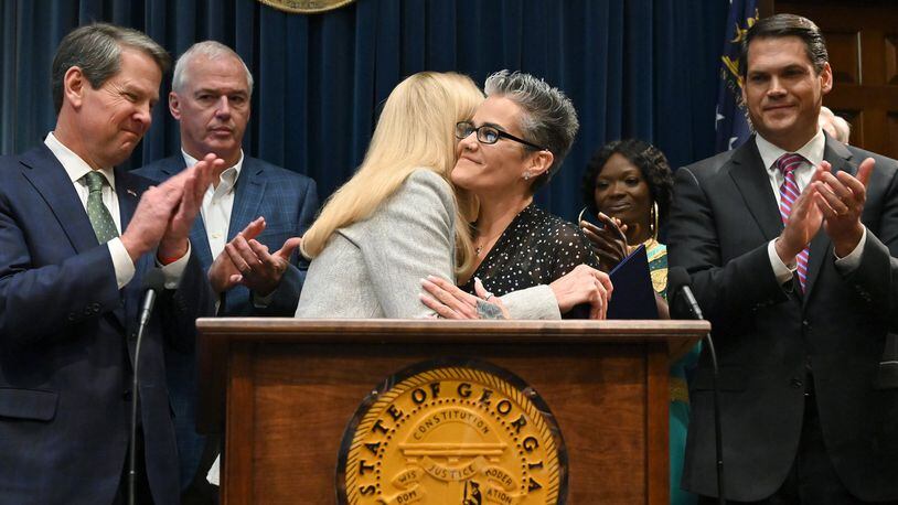 Nikki Burrell, center right, a victim of human trafficking, gets a hug from Georgia first lady Marty Kemp during a press conference Tuesday at the Capitol to announce legislative measures aimed at combating human trafficking. Gov. Brian Kemp, far left, has made the fight against human trafficking one of his top priorities for the legislative session that began last week. (Hyosub Shin / Hyosub.Shin@ajc.com)