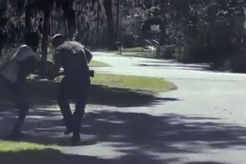In this image from video posted on Twitter Tuesday, May 5, 2020, Ahmaud Arbery stumbles and falls to the ground after being shot as Travis McMichael stands by holding a shotgun in a neighborhood outside Brunswick, Ga., on Feb. 23, 2020.
