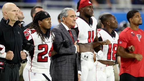 Falcons owner Arthur Blank locked arms with players and coaches during the national anthem before a game in Detroit. Pictured are (from left) coach Dan Quinn, running back Devonta Freeman, Blank, Julio Jones and Taylor Gabriel.