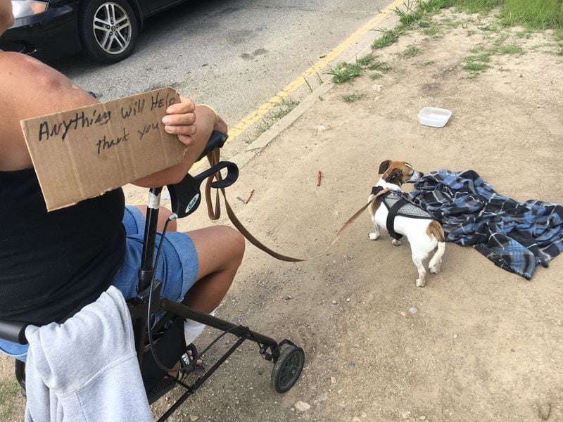 A woman named Robin and her dog named Buddy Boo Boo sit near U.S. 35 and Main Street. “I do this to survive. If they don’t want to give us money they don’t have to,” she said, adding she is trying to get Social Security disability.