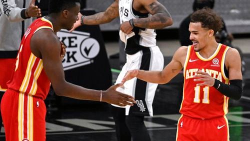 Atlanta Hawks' Trae Young (11) and Clint Capela celebrate the team's double-overtime victory against the San Antonio Spurs in an NBA basketball game Thursday, April 1, 2021, in San Antonio. Atlanta won 134-129. (AP Photo/Darren Abate)
