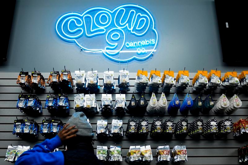 Operational lead Willie Morrow stocks shelves at Cloud 9 Cannabis as the store prepares to open for the first time, Thursday, Feb. 1, 2024, in Arlington, Wash. Cloud 9 is one of the first dispensaries to open under the Washington Liquor and Cannabis Board's social equity program, established in efforts to remedy some of the disproportionate effects marijuana prohibition had on communities of color. (AP Photo/Lindsey Wasson)