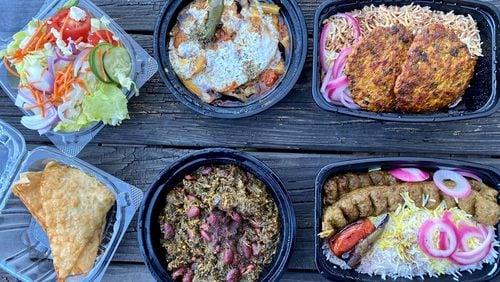 A takeout feast form Olomi’s Grill might include (clockwise from upper left) a complimentary iceberg salad; borani bandjan (eggplant with potatoes); gently spicy chapli chicken kebab; beef kobideh; gormeh sabzi; and chicken samosas.
Wendell Brock for The Atlanta Journal-Constitution