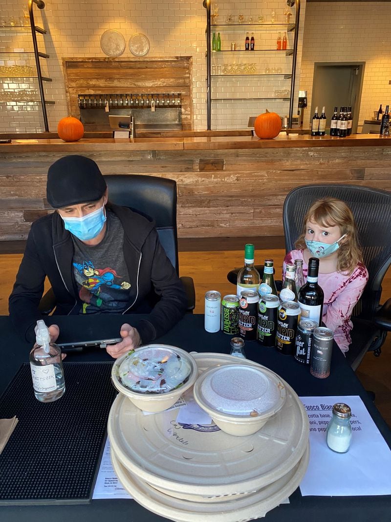 Paul Kelly runs the takeout table at Ammazza, with help from 6-year-old Teddy Connerty, daughter of owner Hugh Connerty. “She loves to talk to customers,” Connerty said. Wendell Brock for The Atlanta Journal-Constitution