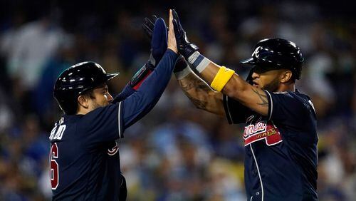 Braves' Eddie Rosario (right) high-fives catcher Travis d'Arnaud at home plate after Rosario's two-run home run during the seventh inning  against the Los Angeles Dodgers Wednesday, Sept. 1, 2021, in Los Angeles. (Marcio Jose Sanchez/AP)