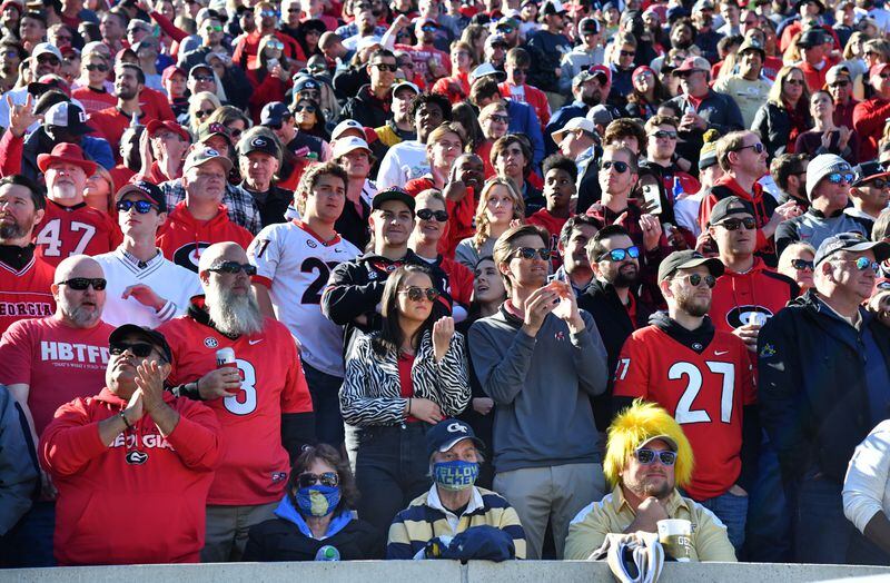Georgia Tech fans are surrounded by Georgia fans during the second half of an NCAA college football game at Georgia Tech's Bobby Dodd Stadium in Atlanta on Saturday, November 27, 2021. Georgia won 45-0 over Georgia Tech. (Hyosub Shin / Hyosub.Shin@ajc.com)
