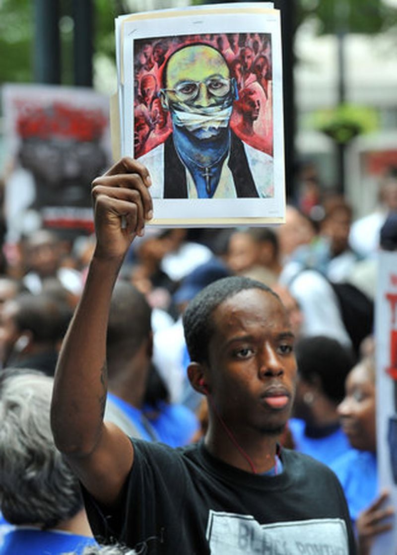 Ishmael Bolden holds a painting of Troy Davis during a march to stop Troy Davis' execution.