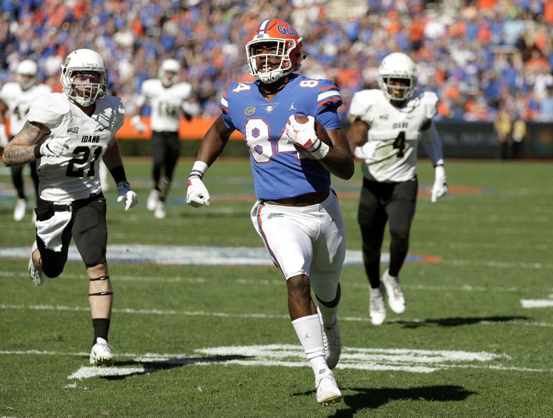 Florida tight end Kyle Pitts, center, runs for a touchdown on a 52-yard pass play past Idaho defensive back Jordan Grabski (21) and defensive back Denzal Brantley (4) during the first half of an NCAA college football game, Saturday, Nov. 17, 2018, in Gainesville, Fla. (AP Photo/John Raoux)