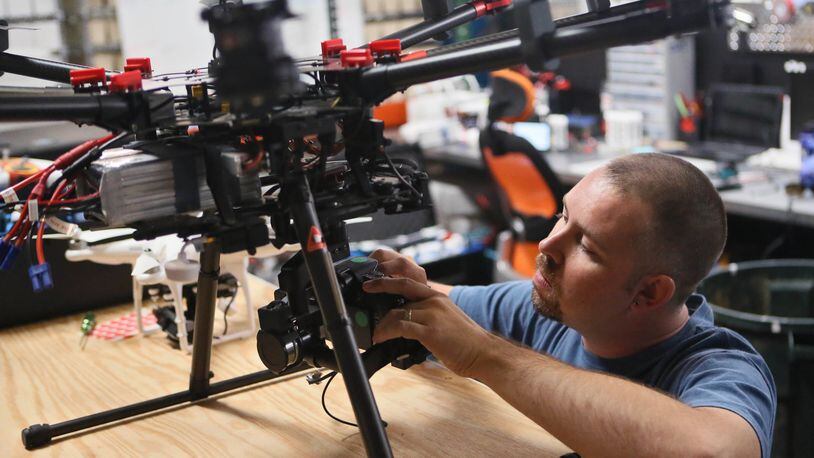 July 10, 2014 - Cumming - Greg Ledford, director of UAV Technology at Atlanta Hobby, prepares a DJI S1000 for flight. The S1000 is designed for professional aerial photography and cinematography. Atlanta Hobby in Cumming is a supplier of DJI/Multirotor products and other unmanned aircraft, and has customers all over the world. As the FAA gradually works toward legalizing commercial drones, Georgia businesses and officials are already gearing up for the day. Several small businesses are already working on drone technology, equipment and military applications; the agriculture industry is eager to explore the possibilities of drones for crop monitoring; GDOT has studied the use of drones for traffic monitoring; and Georgia Tech plans to lead a team to compete to be named a Center of Excellence for unmanned aircraft research. Meanwhile, the state has not yet passed legislation to regulate drones and protect privacy as other states have. BOB ANDRES / BANDRES@AJC.COM Greg Ledford prepares a specialty drone used for filming. AJC photo.