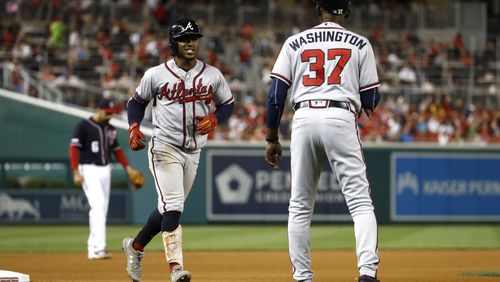 Atlanta Braves' Ozzie Albies, left, rounds the bases past third base coach Ron Washington after hitting a solo home run during the seventh inning of the team's baseball game against the Washington Nationals, Friday, Sept. 13, 2019, in Washington. Atlanta won 5-0. (AP Photo/Patrick Semansky)