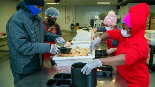 Quinton Way (left, front) & Sallay Sherriss (right, front,) and other workers spoon out meals at Open Hand Atlanta. PHIL SKINNER FOR THE ATLANTA JOURNAL-CONSTITUTION.