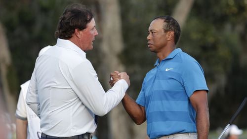 Phil Mickelson, left, shakes hands with Tiger Woods, after the first round of the Players Championship golf tournament, Thursday, May 10, 2018, in Ponte Vedra Beach, Fla. (AP Photo/Lynne Sladky) ORG XMIT: OTK
