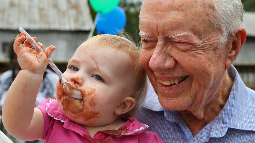 President Jimmy Carter gives 11-month-old Maggie Shoulta a hug while the home town folks of Plains throw their most famous son an ice cream party at Maxine Reese Park on Sunday, Sept. 28, 2014, in Plains, Georgia, to celebrate his 90th birthday. Carter turns 98 Saturday. CURTIS COMPTON / CCOMPTON@AJC.COM