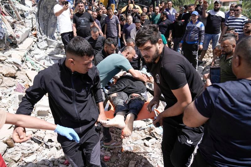 Palestinians remove the body of a dead man after a military operation in the Palestinians town of Deir al-Ghusun, near the West Bank town of Tulkarem, Saturday, May 4, 2024. (AP Photo/Majdi Mohammed)
