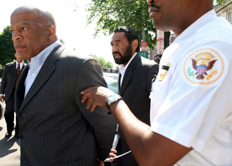 John Lewis is still committed to civil disobedience and has been arrested five times as a congressman. His "good trouble" resume includes two arrests at the South African Embassy in Washington, D.C., to protest apartheid. He was also arrested in 2006 (pictured) and in 2009 for blocking the Sudanese Embassy over that country's genocide in Darfur. His most recent arrest was at an immigration reform protest on the National Mall in 2013. (Lauren Victoria Burke / AP)