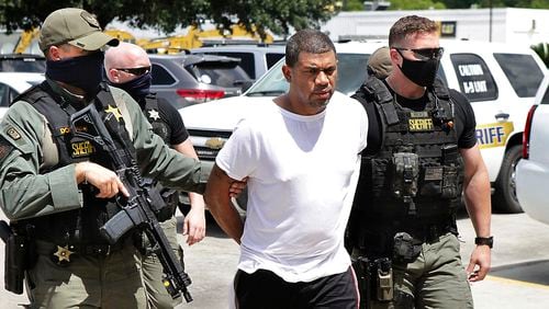 Neil Broussard, escorted by law enforcement, is brought into the Calcasieu Parish Sheriff’s Office Thursday morning, July 16, 2020, in Lake Charles, La. Workers at a Dollar General store recognized Broussard, a convicted sex offender accused of killing two teenagers and kidnapping a third, and locked him in after quietly escorting other customers out. (Donna Price/The Daily Advertiser via AP)/American Press via AP)