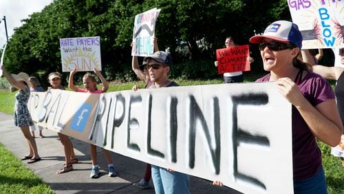 Catherine Doe, right, of West Palm Beach, joins gas pipeline protesters outside of Florida Power and Light headquarters on Universe Boulevard in Juno Beach on October 14, 2016. The Sabal Trail Pipeline is slated to bring natural gas to FPL’s South Florida plants in 2017. Groups oppose the 515-mile pipeline that will start in Alabama and bring fracked gas through several counties in Florida’s springs and wetlands. (Richard Graulich / The Palm Beach Post)