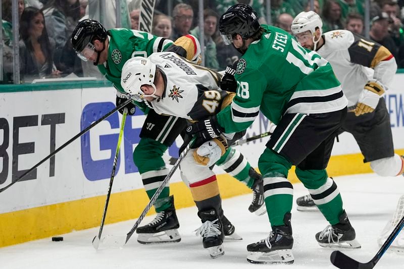 Dallas Stars' Ryan Suter, left, and Sam Steel (18) work to take control of the puck against Vegas Golden Knights' Ivan Barbashev (49) and Nicolas Roy (10) in t he second period in Game 5 of an NHL hockey Stanley Cup first-round playoff series in Dallas, Wednesday, May 1, 2024. (AP Photo/Tony Gutierrez)