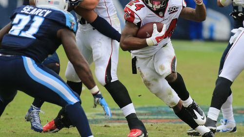 102515 NASHVILLE: -- Falcons running back Devonta Freeman finds some running room against Titans safety Da’ Norris Searcy during the first half in a football game on Sunday, Oct. 25, 2015, in Nashville. Curtis Compton / ccompton@ajc.com