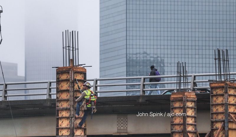 Against a foggy skyline at Mitchell and Magnum streets, construction crews work on Castleberry Park, a mixed-use development on Atlanta's Westside. JOHN SPINK / JSPINK@AJC.COM