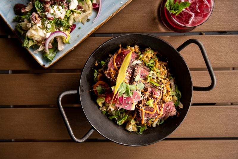 UP on the Roof's Kobe Steak Gyudon Skillet has a seared flat iron with stir-fried rice and white sauce. (Mia Yakel for The Atlanta Journal-Constitution)