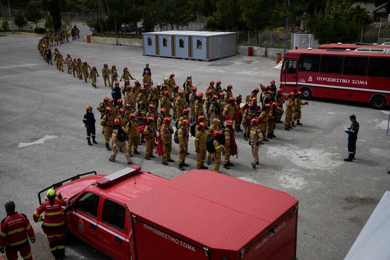 Firefighters in training for the special unit, gather after a practice at the Civil Protection Academy in Villia village some 60 kilometers (37 miles) northwest of Athens, Greece, Friday, April 19, 2024. Greece's fire season officially starts on May 1 but dozens of fires have already been put out over the past month after temperatures began hitting 30 degrees Celsius (86 degrees Fahrenheit) in late March. This year, Greece is doubling the number of firefighters in specialized units to some 1,300, adopting tactics from the United States to try and outflank fires with airborne units scrambled to build breaks in the predicted path of the flames. (AP Photo/Thanassis Stavrakis)