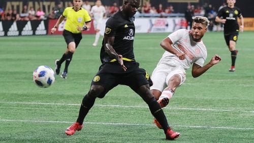 Atlanta United forward Josef Martinez scores in the first half of Sunday's MLS match against the Columbus Crew at Mercedes-Benz Stadium. The goal, scored past Columbus defender Jonathan Mensah, was his 27th of the season, tying the league record for goals in a season. Curtis Compton/ccompton@ajc.com