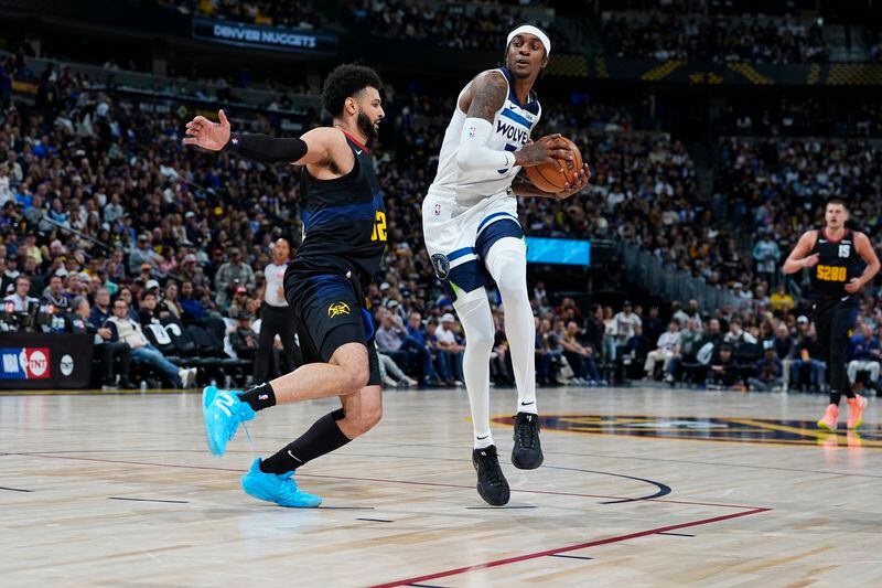 Minnesota Timberwolves forward Jaden McDaniels, right, drives to the basket as Denver Nuggets guard Jamal Murray defends during the second half of Game 2 of an NBA basketball second-round playoff series Monday, May 6, 2024, in Denver. (AP Photo/David Zalubowski)