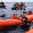 FILE - Migrants aboard a rubber boat end up in the water while others cling on to a centifloat before being rescued by a team of the Sea Watch-3, around 35 miles away from Libya, Monday, Oct. 18, 2021. European Union nations will discuss on Tuesday, May 14, 2024, sweeping new reforms to the bloc's failed asylum system as campaigning for Europe-wide elections next month gathers pace, with migration expected to be an important issue. (AP Photo/Valeria Mongelli, File)