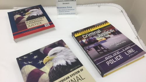 Gwinnett County school officials display textbooks and other materials they planned to use in some courses in September 2016. ERIC STIRGUS / ESTIRGUS@AJC.COM