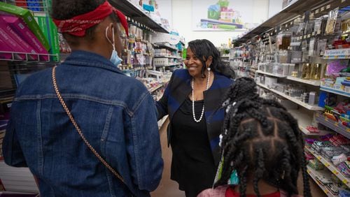 Atlanta City Councilwoman Andrea Boone talks to two girls while shopping for gifts at Walmart. Boone took five local families, including children, on a holiday shopping trip. (BRANDEN CAMP FOR THE ATLANTA JOURNAL-CONSTITUTION)