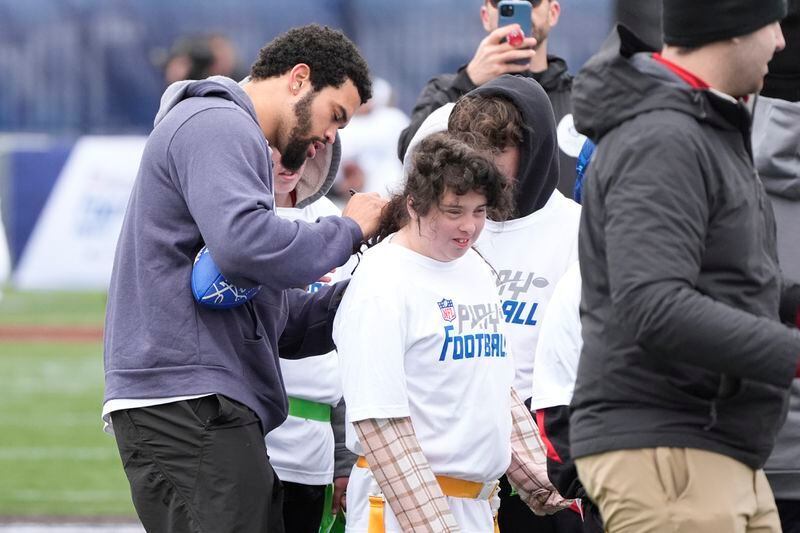 USC quarterback Caleb Williams autographs an athlete's shirt during an NFL Football Play Football Prospect Clinic with Special Olympics athletes, Wednesday, April 24, 2024 in Detroit. (AP Photo/Carlos Osorio)