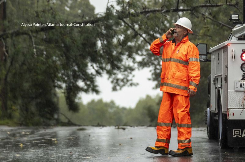 John Wanek, crew lead with Walton EMC, assess a power line that was damaged by a fallen tree on Valley Dale Drive SW in Lilburn, Georgia.

