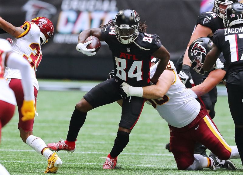 Falcons running back Cordarrelle Patterson runs for yardage against Washington Football Team defenders for a first down during the first quarter Sunday, Oct. 3, 2021, at Mercedes-Benz Stadium in Atlanta. (Curtis Compton / Curtis.Compton@ajc.com)
