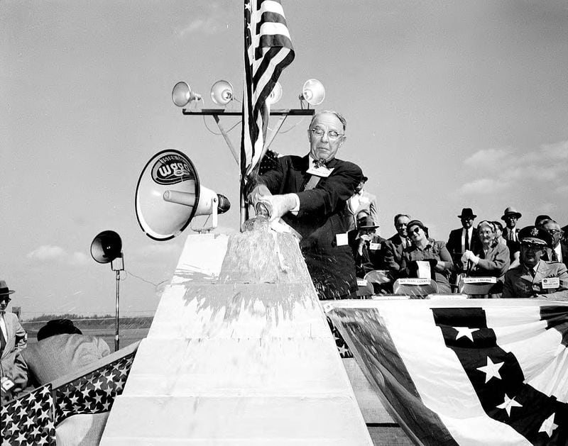 Atlanta Mayor William B. Hartsfield dedicates the Buford Dam on Oct. 9, 1957, by crashing a Coca-Cola bottle against a platform. (Lane Bros. Commercial Photographers / GSU Library LBME1-026c)