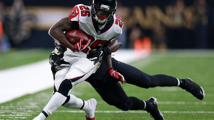 Tevin Coleman #26 of the Atlanta Falcons runs with the ball as Demario Davis #56 of the New Orleans Saints defends during the first half at the Mercedes-Benz Superdome on November 22, 2018 in New Orleans, Louisiana. (Photo by Sean Gardner/Getty Images)